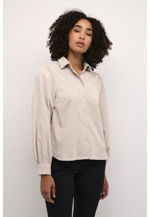 Lichtbeige button-down shirt van een zachte, gestructureerde stof. Bevat een kraag, gepofte mouwen en een gebogen zoom. Geschikt voor casual draag.