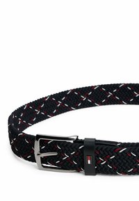 Tkaniony czarny pasek z czerwonymi i białymi akcentami, z błyszczącą srebrną klamrą i szczegółami logo na pasku klamry. Teksturowany i elastyczny design.