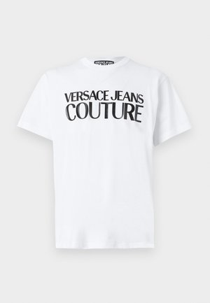 White t-shirt featuring bold black text "VERSACE JEANS COUTURE." Short sleeves, round neckline, soft cotton material.