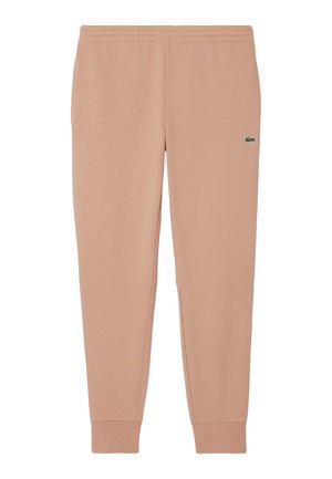 Pantaloni della tuta rosa con una texture morbida, gambe affusolate, una vita elastica e un piccolo logo verde sulla coscia sinistra.