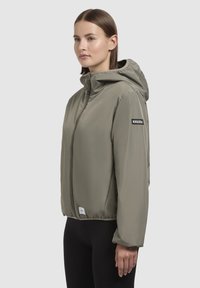 Khaki hooded jacket with a front zipper, elastic cuffs, and a logo patch on the sleeve, featuring a smooth, lightweight fabric.