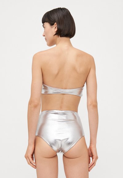 Set de bikini metalic argintiu, format din două piese, cu un top fără bretele și un fund înalt, având o textură netedă și lucioasă.
