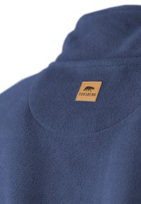 Navyblauer Fleece-Besatz mit einem gebogenen Kragen und einem hellbraunen Lederetikett, das das Wort "FORSBERG" und ein Bären-Symbol zeigt. Weiche Textur.