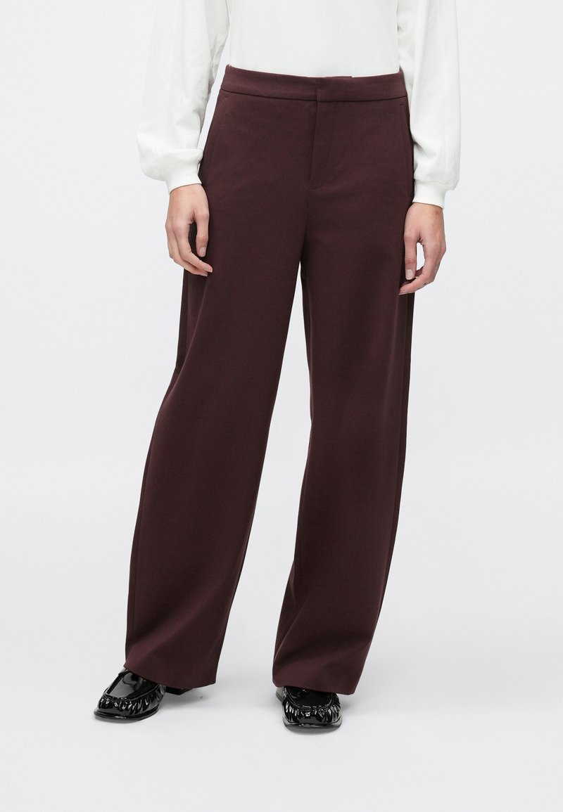 Vinrøde bukser med vide ben lavet af et glat stof, med en tætsiddende talje og uden synlige lommer eller pynt.