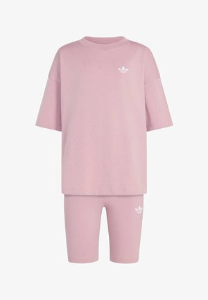 Różowy, oversize T-shirt z krótkim rękawem oraz pasujące krótkie spodenki do kolan z białymi logo Adidas trefoil na piersi i udzie.