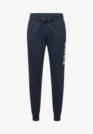 Pantalon de jogging bleu marine avec taille élastique et cordon, poignets côtelés aux chevilles, et logo blanc vertical "BOSS" sur la jambe droite.