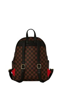 Zaino a quadri marrone e nero con accenti rossi a contrasto, spallacci in pelle e hardware dorato. Parte superiore arrotondata e doppie spalline.