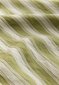Textil con franjas alternas en verde y crema, con una textura suave y arrugada. Las franjas están bordeadas por líneas blancas delgadas.