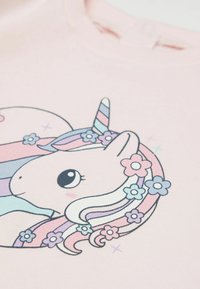 Różowy bawełniany sweter z kapturem z rysunkowym jednorożcem z paskowym rogiem i kwiatowymi akcentami w odcieniach niebieskiego i różowego. Gładka faktura i okrągły dekolt.