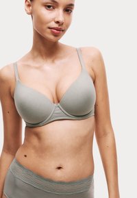 Sostén de color gris claro con relleno y tirantes ajustables, que presenta una tela suave y un diseño sin costuras, combinado con un fondo a juego acentuado con encaje.