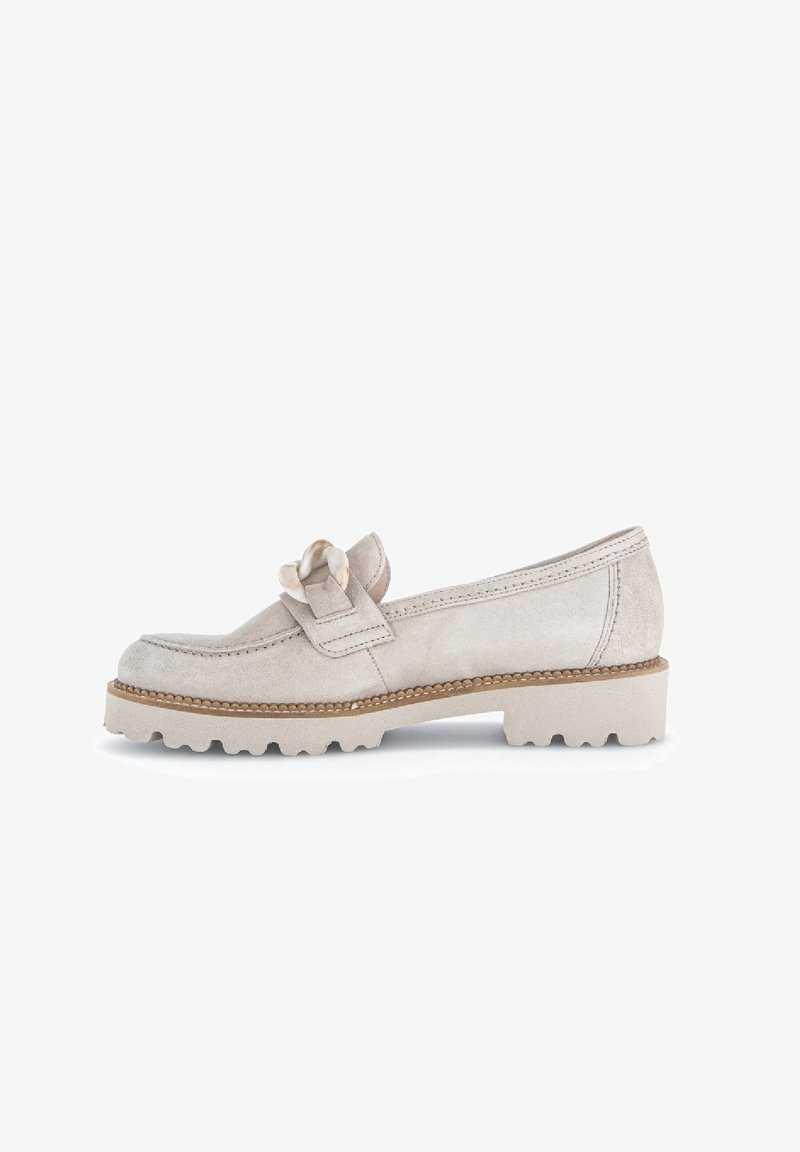 Mocassin en daim beige avec semelle épaisse et détail de bride nouée décorative, vue de côté sur fond blanc.