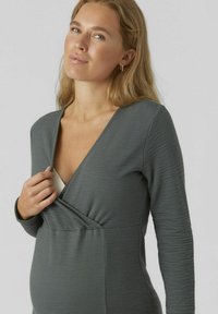 Grijze lange mouw jurk met een diepe V-hals en een gestructureerde stof, ontworpen voor een aansluitende pasvorm met kruislings voorpaneel.