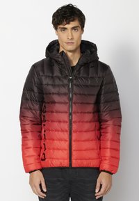 Giacca a vento con una gradazione di colore che va dal nero al rosso, dotata di chiusura con zip, cappuccio e un marchio ben visibile sul lato. Tessuto trapuntato.
