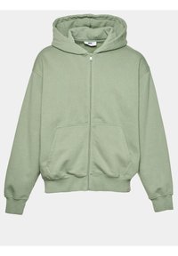 Haut à zip vert fabriqué en tissu doux. Dispose d'une capuche spacieuse, de deux poches avant et de poignets et d'un ourlet à côtes.