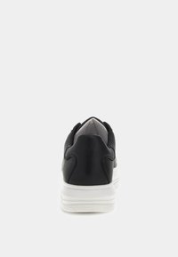 Sneaker in pelle nera con punta arrotondata, colletto imbottito e suola in gomma bianca. Texture liscia con dettagli di cucitura discreti sul tallone.