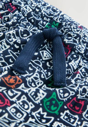 Mørkeblå stofshorts med legesyge hvide, røde, grønne og orange tegneseriefigur-mønstre; har en justerbar fletningssnor.