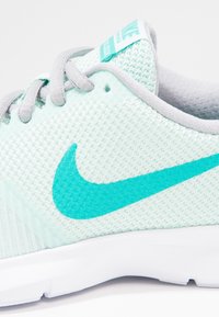 Scarpa da corsa a rete verde chiaro con logo swoosh teal, lacci grigi e suola bianca. Presenta una parte superiore testurizzata per la traspirabilità.