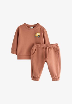 Tweedelig kinderoutfit van rustkleurige katoen. Bevat een longsleeve top met gele tractor borduursel en bijpassende broek met elastische taille.