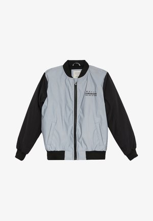 Veste bomber gris clair et noire avec fermeture éclair, poignets côtelés et texte brodé sur la poitrine. Texture lisse, design matelassé.