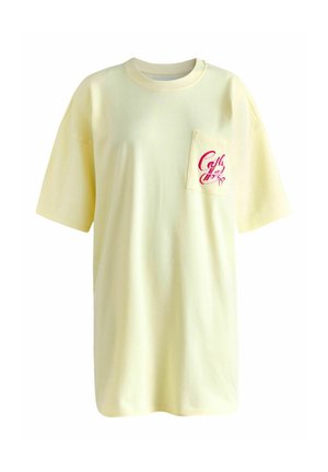 Jasnożółta, luźna koszulka z krótkim rękawem z kieszenią na piersi z czerwonym tekstem pisanym kursywą "Cali Miss".
