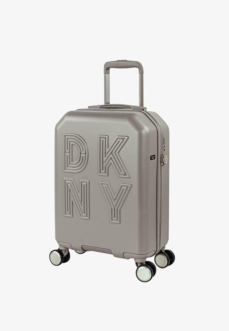 Maleta rígida gris con el logo en relieve "DKNY", asa telescópica y cuatro ruedas de desplazamiento suave. Bordes redondeados y cierre con cremallera.