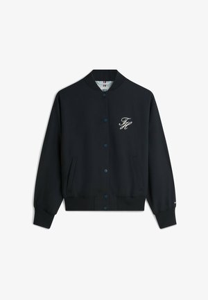 Marine bomberjack met ribbelkraag en manchetten. Beschikt over twee zijzakken, knoopsluiting en een wit geborduurd logo op de borst.