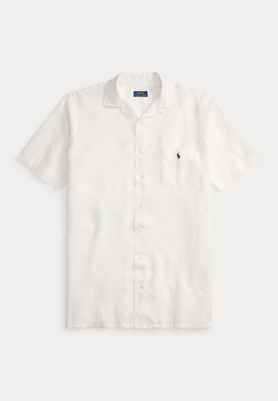 Īsām piedurknēm balta lina krekls ar piespraužamu apkakli, priekšējo kabatu un nelielu tumši zilu logotipu kreisajā krūtīs. Rūtainas faktūras audums.