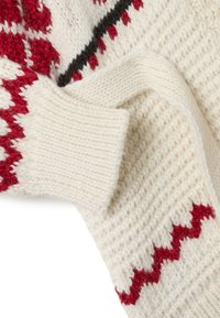 Suéter de punto que presenta una base color blanco roto con patrones geométricos en rojo y negro, hilo texturizado y puños acanalados para mayor calidez y comodidad.