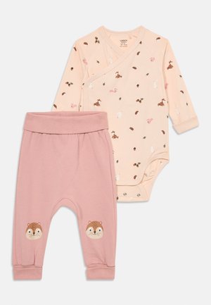 Roze bodysuit met dierenprint en wikkelontwerp, gecombineerd met roze broeken met egeltjesgezichten op de knieën. Zachte katoen stof.