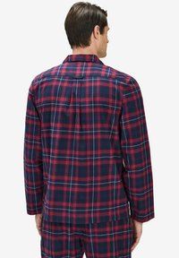 Långärmad rutiga pyjamas set i marinblått, rött och vitt. Har en klassisk krage och strukturerad tyg med en avslappnad passform.