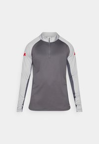 Αθλητικό πουκάμισο μακρυμάνικο σε γκρι χρώμα με γκρι λεπτομέρειες. Διαθέτει φερμουάρ τετάρτου μήκους στο γιακά και κόκκινο λογότυπο στο αριστερό μανίκι. Ομαλή υφή υφάσματος.