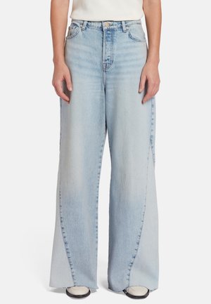 Jeans large bleus clairs avec ourlet irrégulier, design classique à cinq poches, et décoloration subtile. Fabriqués en denim à la texture lisse.