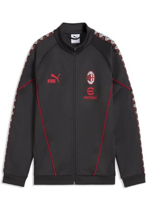Czarna sportowa kurtka Puma z czerwonym logo AC Milan, czerwonym logo Puma z napisem "KING", czerwonym logo "Football" i wzorzystymi paskami na rękawach.