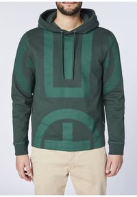 Felpa verde con un grande motivo geometrico, dotata di cappuccio con coulisse, polsini a coste e texture morbida. Progettata per una vestibilità rilassata.