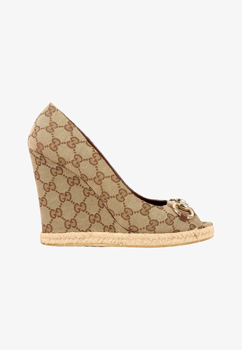 Chaussure à talon compensé beige avec motif GG marron entrelacé, semelle en jute, bout ouvert et détail du logo double G doré sur le devant.