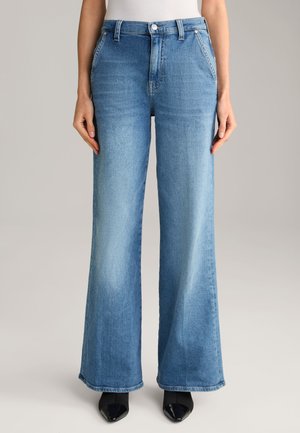 Light blue wide-leg jeans made from denim, featuring a high waist, side pockets, and a slightly faded finish. Paired with black heeled shoes.