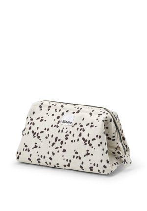 Canvas cosmetic pouch in beige with black abstract speckles, zip closure, and white brand label. Structured shape with a flat base.