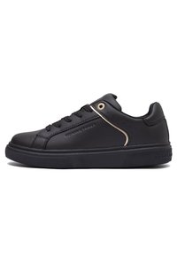 Sneaker in pelle nera con profilo basso, punta tonda e accenti dorati sul lato. Presenta suola in gomma testurizzata e lacci neri piatti.