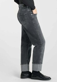 Jeans en denim gris à taille haute, jambes larges et revers roulés ; dotés de deux poches arrière avec un detail de couture et une fermeture à boutons.