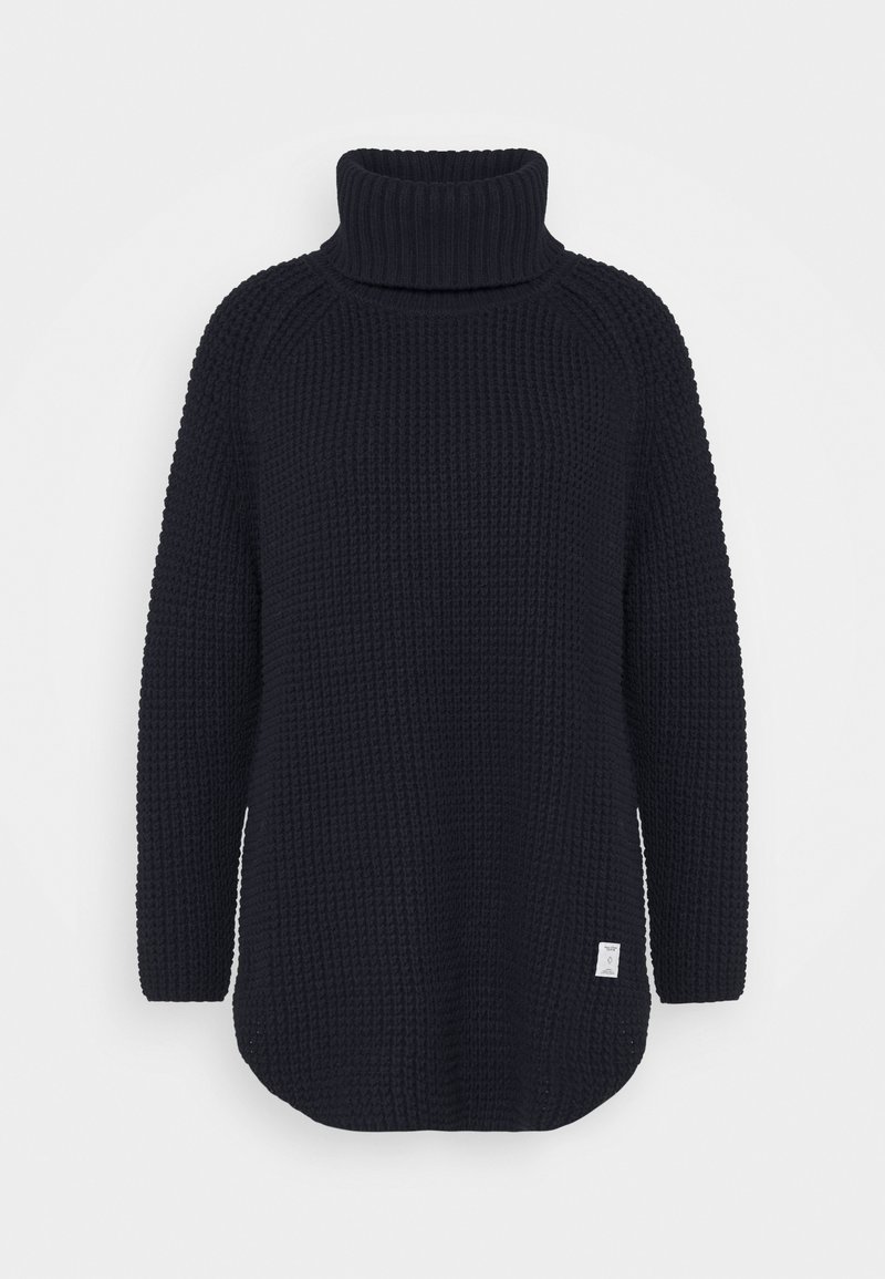 Pull à col roulé en grosse maille noire avec manches longues et petite étiquette blanche sur le bas devant.