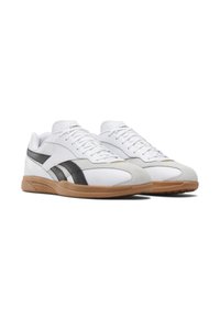 Scarpe sportive bianche con tomaia in pelle liscia, accenti in camoscio grigio, strisce laterali nere e suola in gomma marrone.