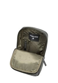 Bolsa negra con cremallera y un interior de tela verde oliva, que presenta un pequeño bolsillo con cremallera y una etiqueta que dice "STRELLSON". Diseño exterior texturizado.