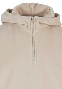 Fleece pullover in licht beige met een half-rits aan de voorkant. Beschikt over een comfortabele capuchon en zachte, gestructureerde stof. Minimalistisch ontwerp, geen zichtbare patronen.