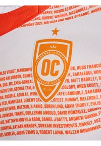 Witte sporttrui met een oranje wapen waarop "Orange County Soccer Club" en "OC." staat. Bevat namen in oranje letters over de stof.