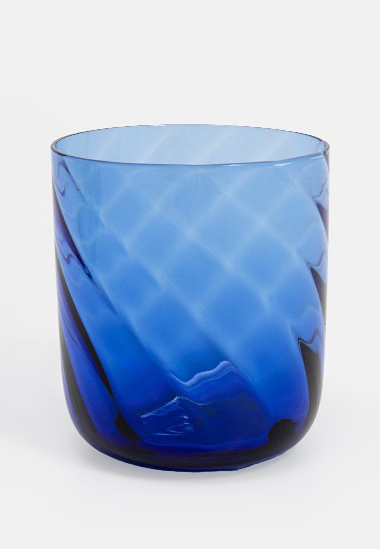 Taza de vidrio azul con un diseño ondulado. La superficie presenta un patrón de diamantes texturizado, que va de azul claro a azul oscuro en la base.