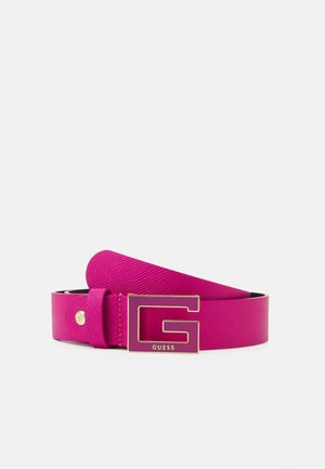 Felroze gestructureerde riem met een grote gouden en roze "G" gesp met de merknaam Guess op een witte achtergrond.