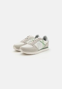 Sneaker mit einer hellgrauen und weißen Oberseite sowie grünen Akzenten, aus Leder und Stoff gefertigt, mit einer strukturierten Sohle und Schnürverschluss.