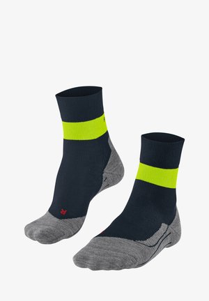 Calzini blu navy con una vivace striscia verticale gialla. Sezioni del piede e del tallone grigie. Realizzati in un tessuto testurizzato ed elastico, adatto per l'abbigliamento sportivo.