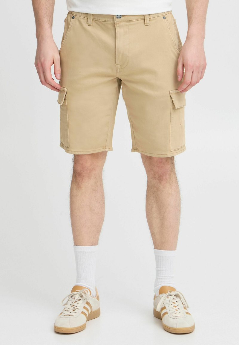 Pantalones cortos cargo beige con múltiples bolsillos, hechos de algodón, con un frente plano, trabillas para cinturón y una longitud casual por encima de la rodilla.