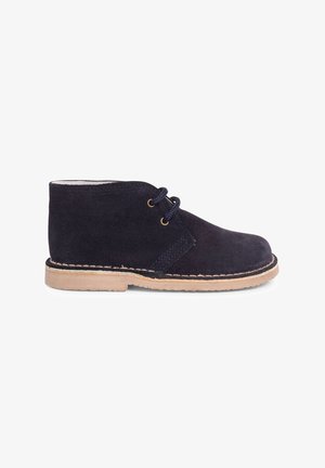 Stivale in suede blu navy con suola in gomma marrone chiaro, punta rotonda e design con lacci che presenta due occhielli e cuciture a contrasto.
